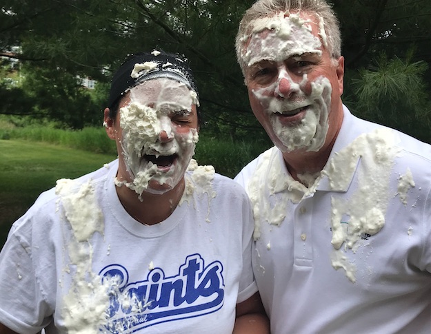 two people hit in the face with pie